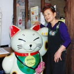 「瀬戸の味を食べに来て」と、吉見都代子店長と、入り口で客を迎える招き猫の「ハナちゃん」 【写真をクリックで拡大】