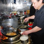真剣な表情で麻婆豆腐を調理する横江さん 【写真をクリックで拡大】